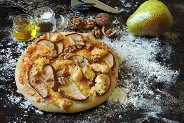 Homemade pizza with pear, cheeses and walnuts.