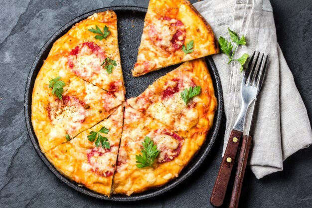 Homemade pizza with salami on slate