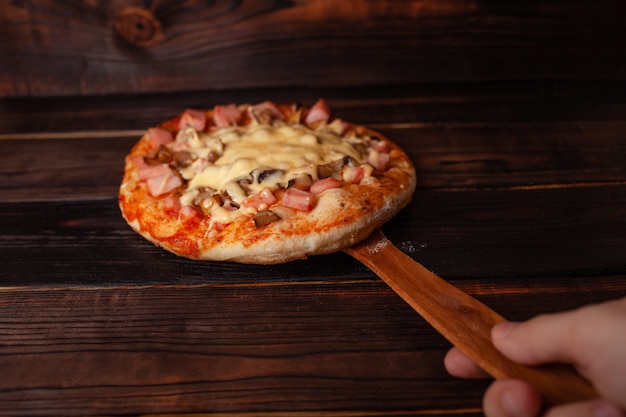 Homemade pizza on a wooden brown