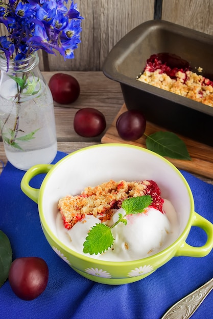 Homemade plum crumble and ice cream, selective focus