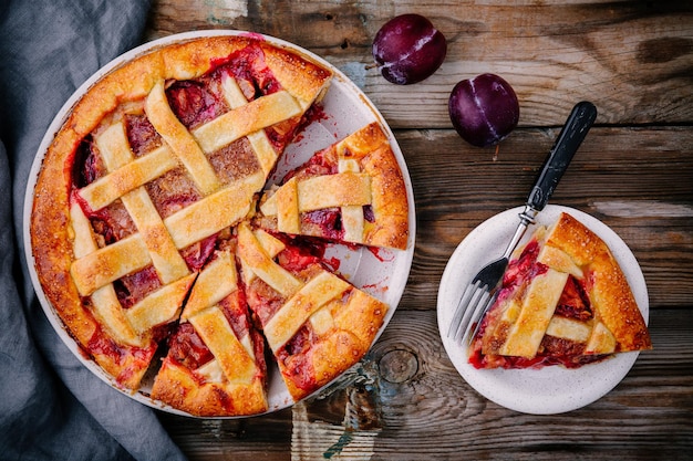 Homemade plum pie on rustic background Top view