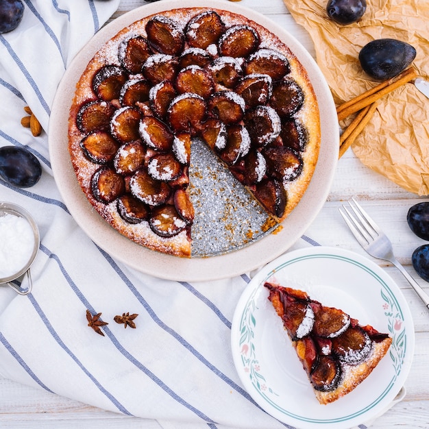 Homemade plum pie on the wooden surface