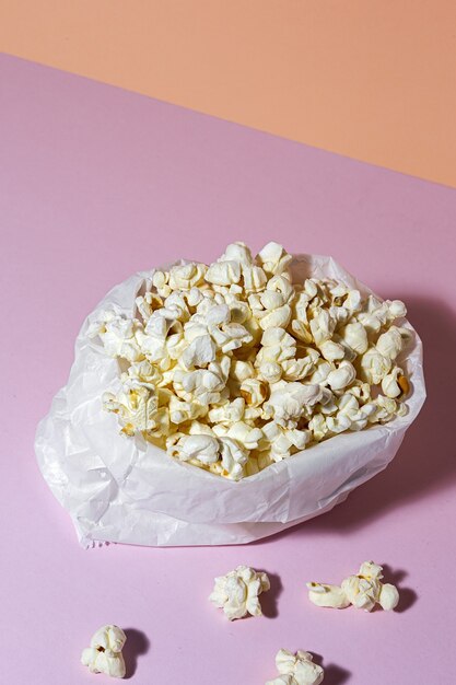 Photo homemade popcorn on colored table with high contrast light. snack concept