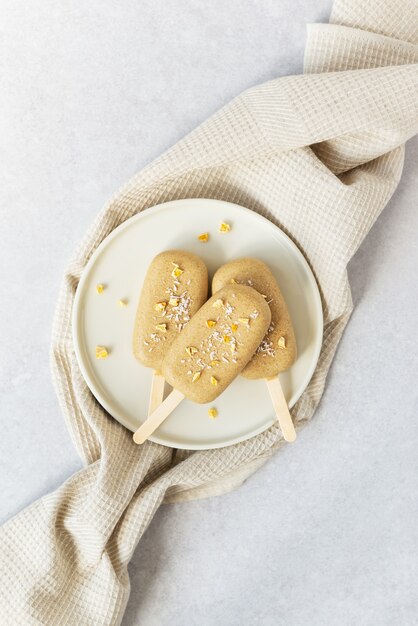 Homemade popsicle on a stick with chocolate cashews on a towel