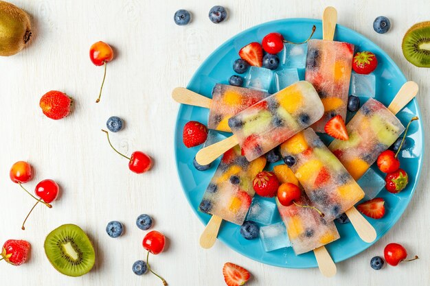 Homemade popsicles with berries and fruits, top view.