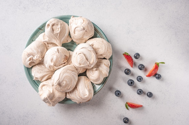 Homemade popular dessert meringue on plate on a light surface