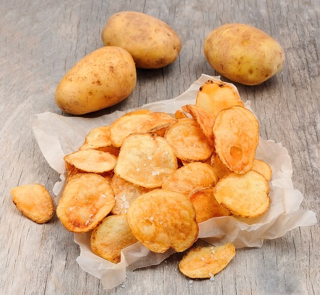 Homemade potato chips closeup on wooden texture