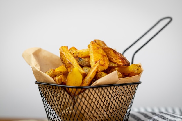 Homemade potato fries in a metal basket