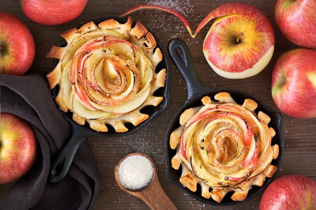 Homemade puff pastries with rose shaped apple slices baked in iron skillet