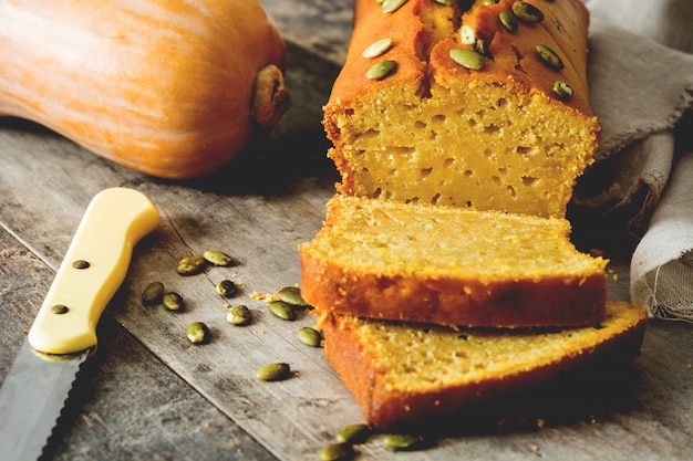 Homemade pumpkin bread on wooden table.