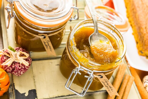 Homemade pumpkin butter with pumpking bread on the table.