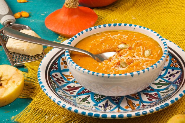 Homemade pumpkin cream soup with parmesan cheese and peeled pumpkin seeds,