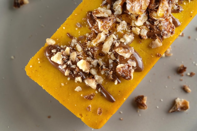 Homemade pumpkin pie with chocolate and nuts Sprinkled with walnuts Macro shot Top view