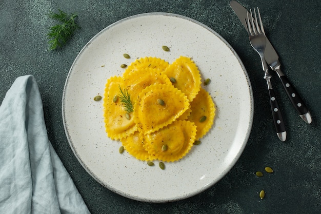 Homemade Pumpkin Ravioli met boter op een donker beton