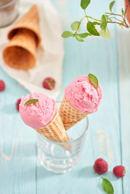 Homemade raspberry ice cream in waffle cones. Summer time