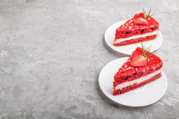 Homemade red velvet cake with milk cream and strawberry on a gray background