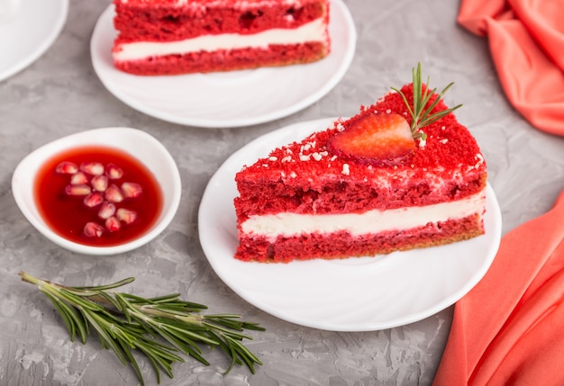 Homemade red velvet cake with milk cream and strawberry on a gray concrete surface. side view, selective focus.