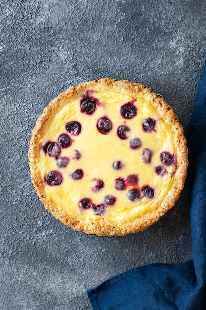 Torta di ricotta fatta in casa con ciliegie su sfondo grigio vista dall'alto cottura abbondante