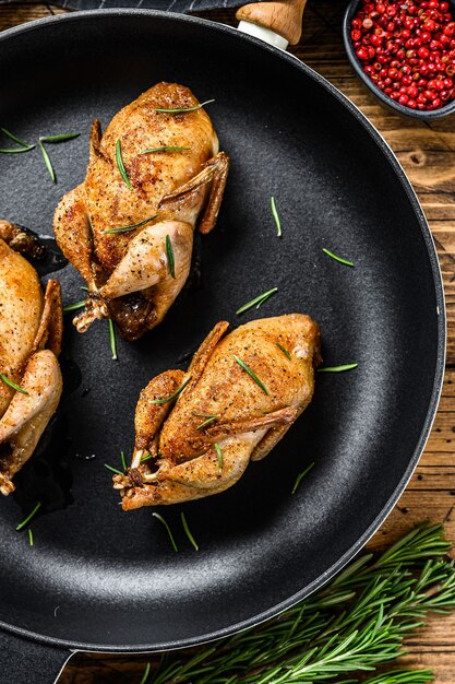 Homemade roast pigeon quail in a pan.