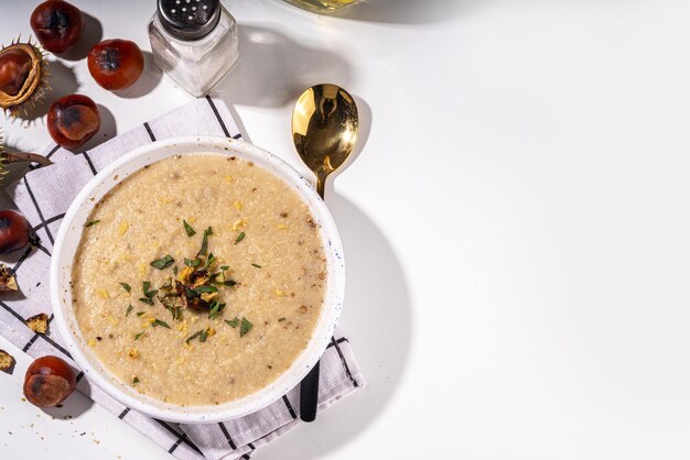 Homemade roasted chestnut soup Autumn cream soup with chestnuts on white background