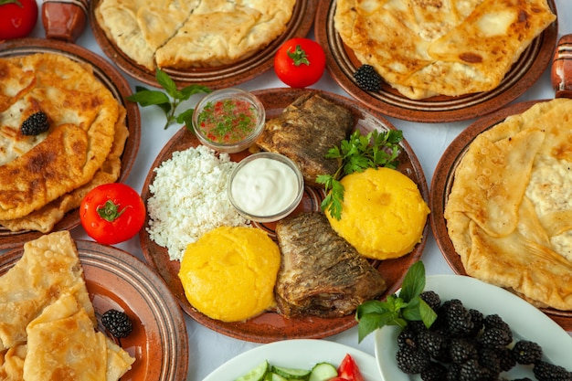 Домашняя румынская еда с жареной рыбой, полента, пироги, овощи с красным вином