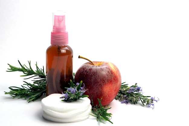 Homemade rosemary facial tonic in a transparent bottle a few branches of rosemary