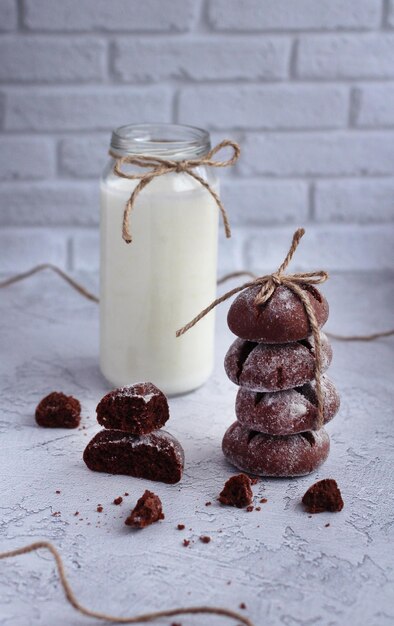 Homemade round gingerbread with cinnamon in powdered sugar with pieces of gingerbread and milk