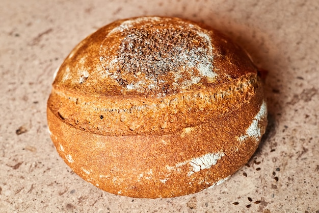 Homemade round rye bread is baked in the oven on a baking stone