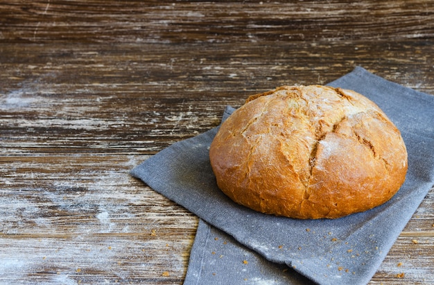 Homemade rustic crusty bread with linen napkin. Food background with copy space.