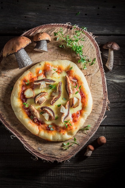 Homemade rustic pizza with noble mushrooms and thyme