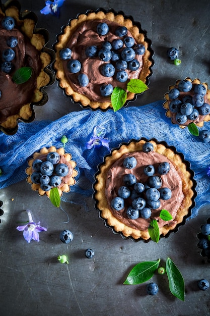 Photo homemade and rustic tarts with blueberries chocolate cream and berries