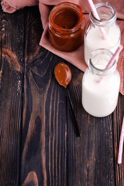 Homemade salted caramel on a dark table with a beautiful black spoon and milk.