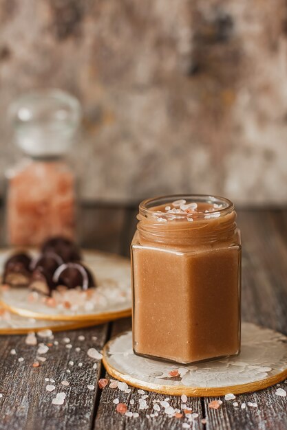 Homemade salted caramel sauce in jar on vintage background