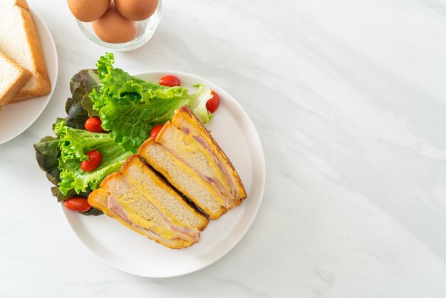 homemade sandwich ham cheese with salad on white plate