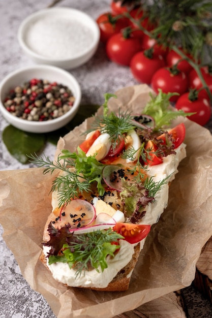 Photo homemade sandwich with ham, cucumber, radish sprouts on wooden board, top view