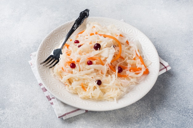 Homemade sauerkraut with carrots and cranberries in plate.