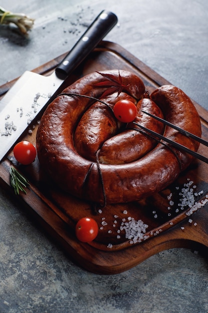 Homemade sausage cooked on a grill, with tomatoes