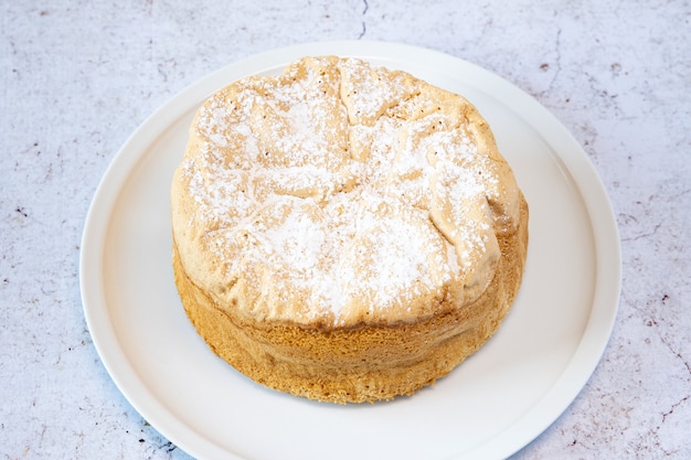 Homemade Savoie cake on a pretty white porcelain dish