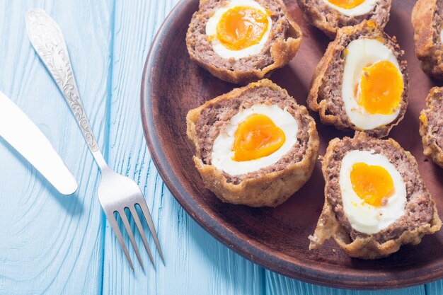 homemade scotch eggs on rustic wooden background