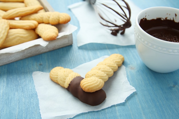 Biscotti di biscotto al burro casalinghi con cioccolato su fondo di legno blu