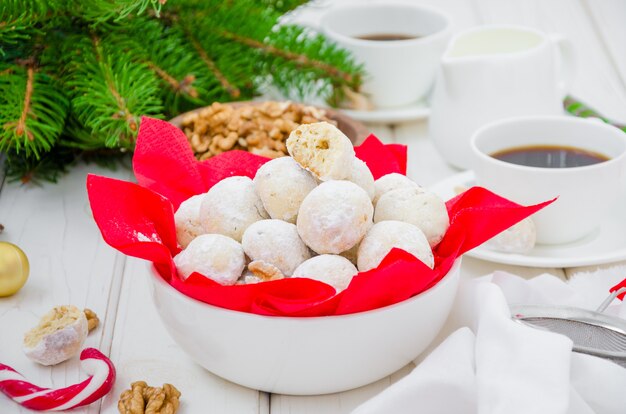 Biscotti casalinghi delle palle di neve con le noci in zucchero a velo in una ciotola