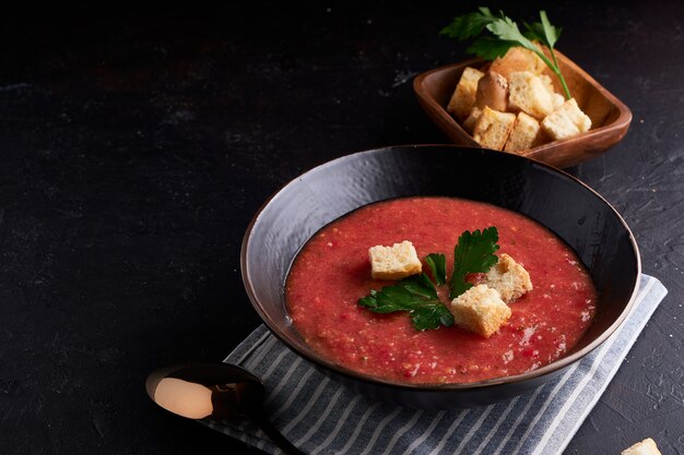 Homemade Spanish tomato soup Gazpacho with spice in black bowl