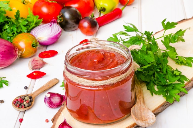 Salsa di pomodoro piccante fatta in casa o ketchup su uno sfondo bianco