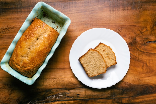 Homemade sponge cake in blue ceramic mold on wooden table Sliced Pound cake