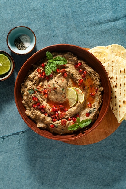 Homemade spread of baked eggplant baba ganoush in a bowl with pomegranate seeds