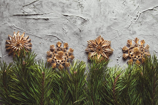 Photo homemade straw decor on christmas tree close up. on a gray concrete background.