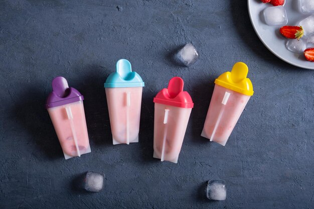 Homemade strawberry ice cream on dark stone table frozen fruit juice vintage style top view