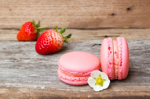 Homemade strawberry macaroons on wooden background