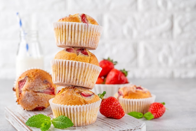 Homemade strawberry muffins or cupcakes on a board on a gray background Selective focus Copy space