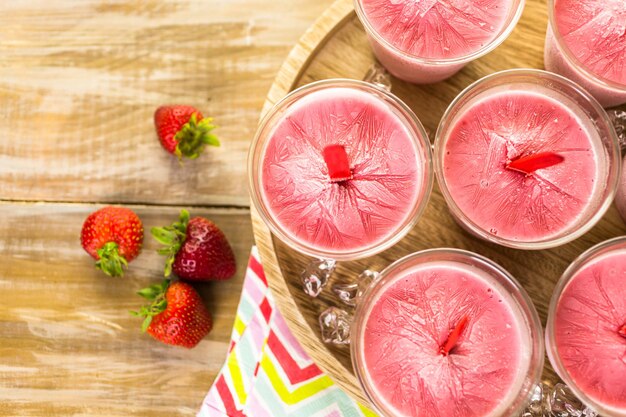 Homemade strawberry popsicles made in plastic cups.